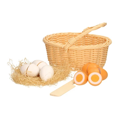 Couper des œufs en bois dans un panier en osier en plastique